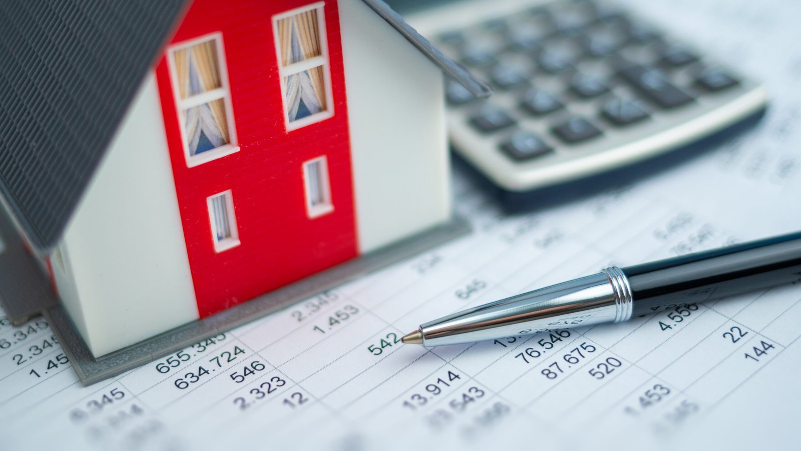 Immobilienberatung bei der Finanzierung, Blick auf ein Haus mit Zahlen